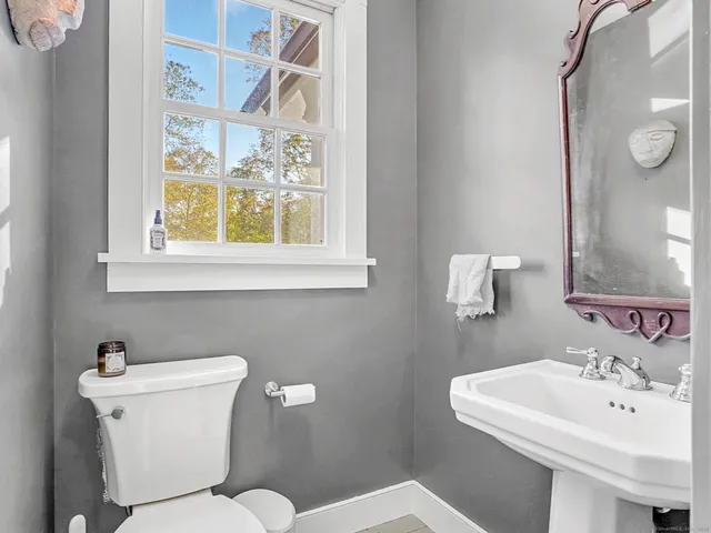 a bathroom with a sink mirror and toilet