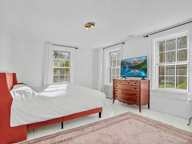 a bedroom with furniture and a flat screen tv