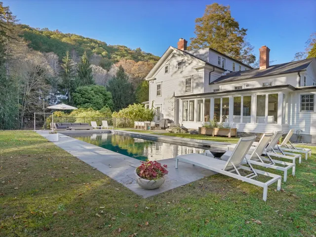 a swimming pool with outdoor seating and yard