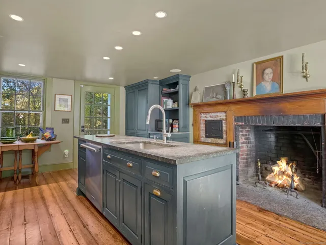 a kitchen with kitchen island granite countertop a sink stove and cabinets
