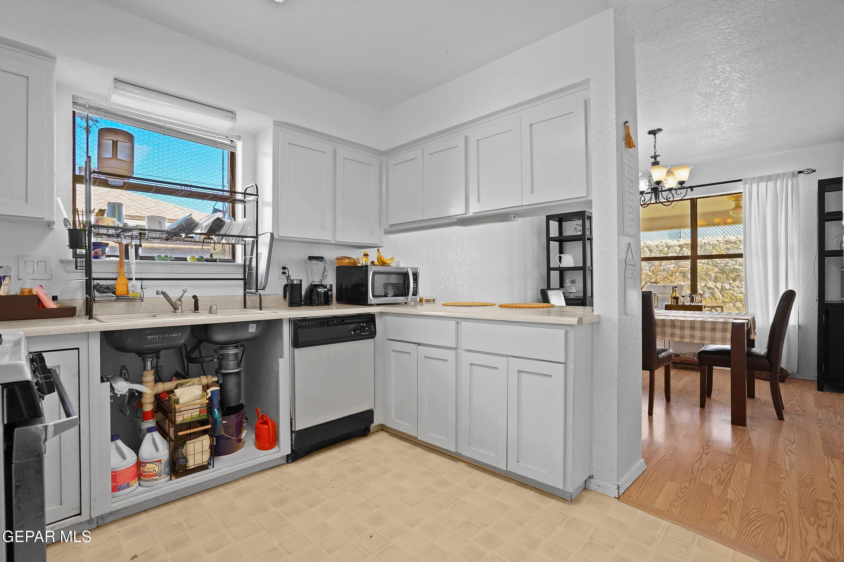 11635 Rufus Brijalba Drive El Paso, TX 79936 - Photo 13 of 32 a kitchen with stainless steel appliances granite countertop a refrigerator a stove and white cabinets with wooden floor