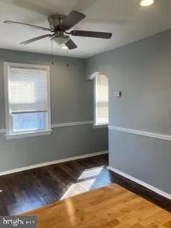 a view of empty room with window and ceiling fan
