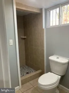 a white toilet sitting next to a bathroom sink and a shower