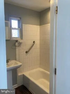 a white bath tub sitting next to a white sink and vanity