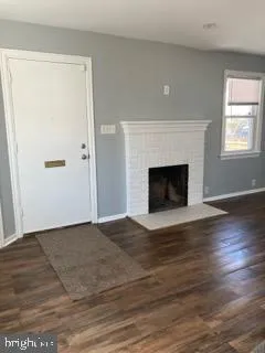 a view of empty room with wooden floor and fireplace