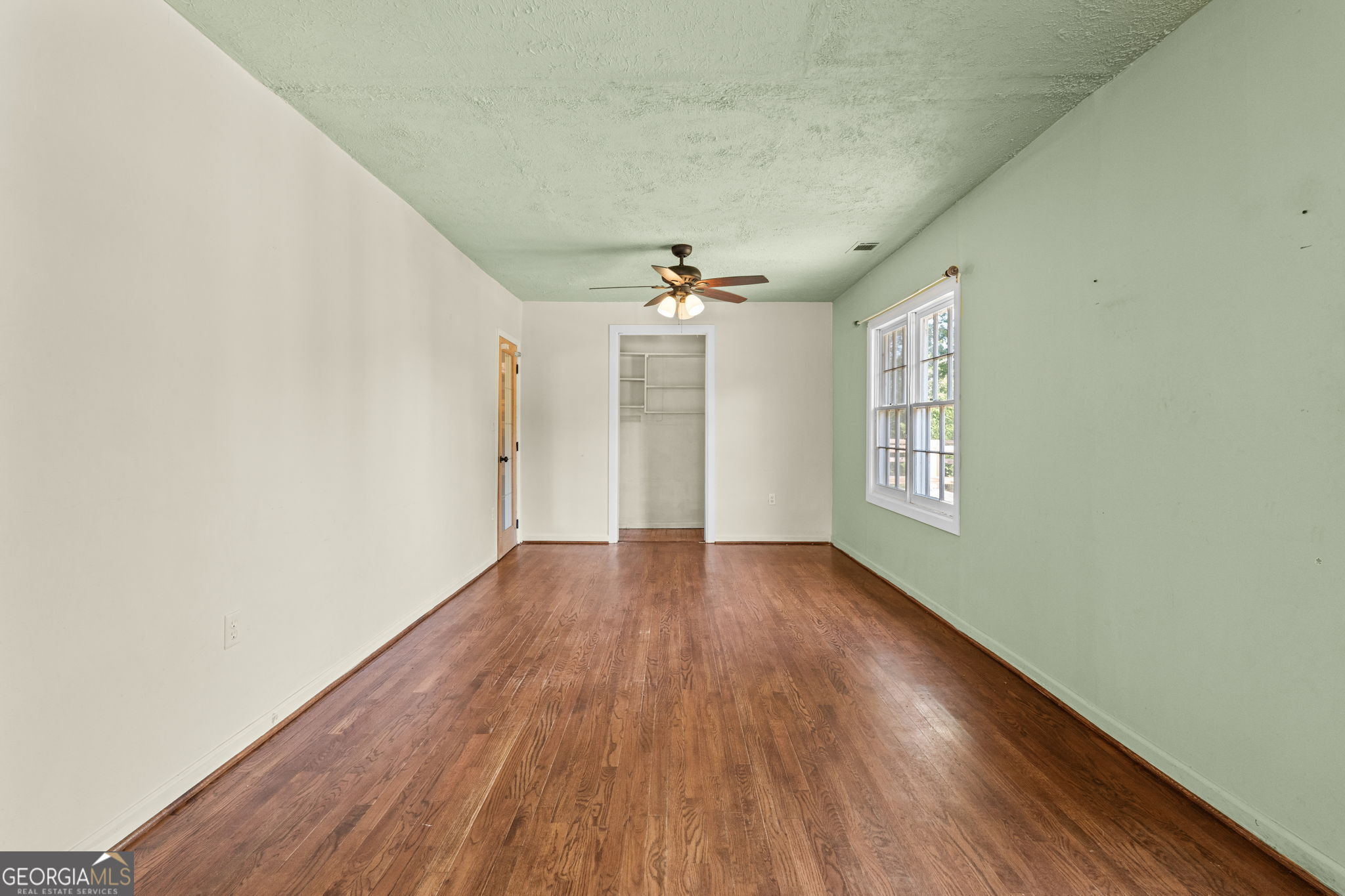 49 Frost Road Bowdon, GA 30108 - Photo 16 of 60 an empty room with wooden floor chandelier and windows