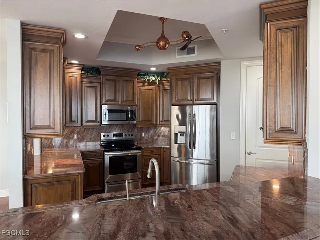 a kitchen with stainless steel appliances granite countertop a refrigerator stove and sink