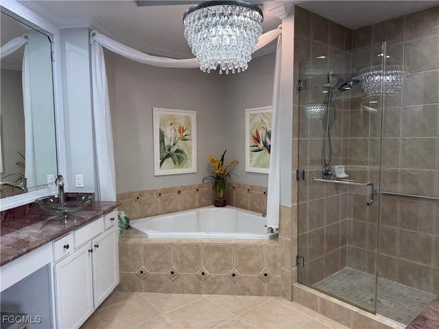 a bathroom with a granite countertop bathtub a sink and a mirror