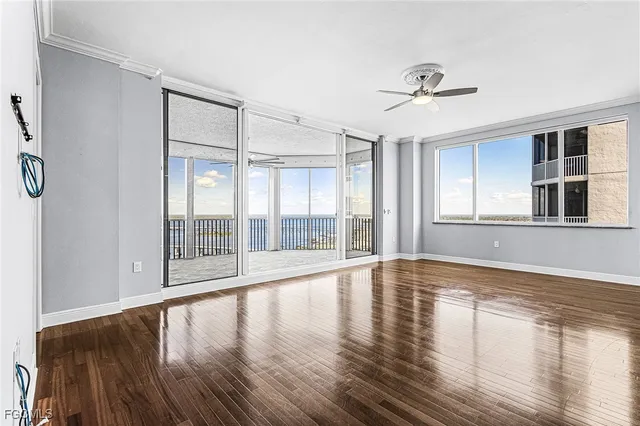 a view of empty room with wooden floor and fan