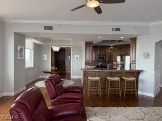 a living room with furniture a rug and kitchen view