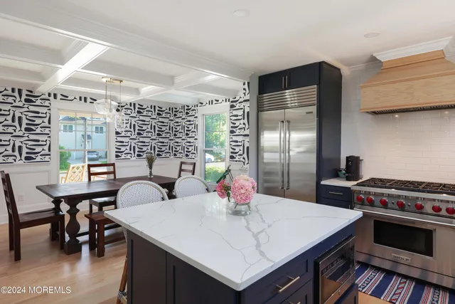 a kitchen with a stove a refrigerator and a dining table with wooden floor