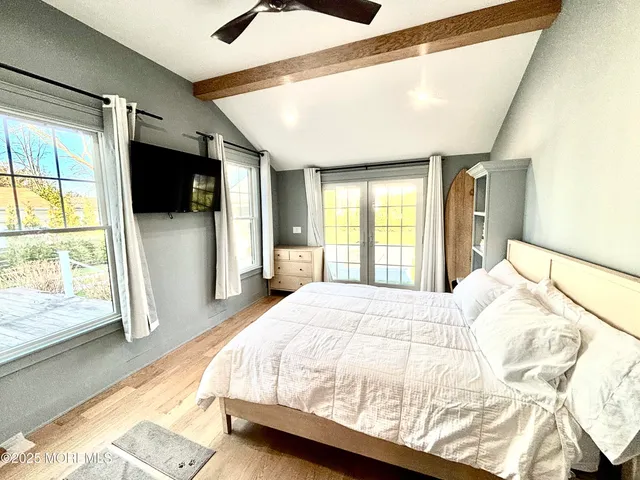 a bedroom with a bed mirror and windows