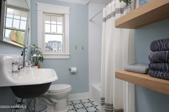 a bathroom with a toilet a sink and a mirror