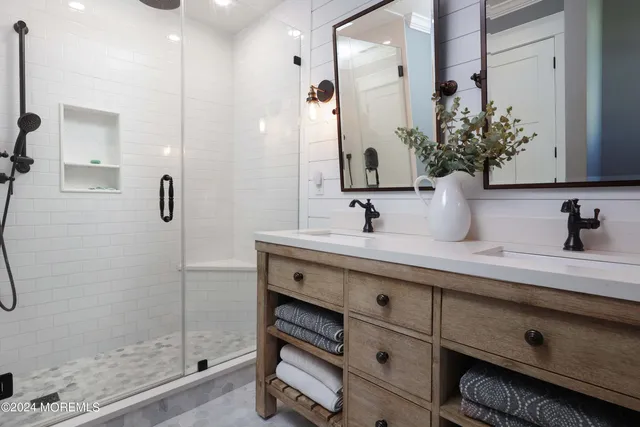 a bathroom with a double vanity sink a mirror and shower