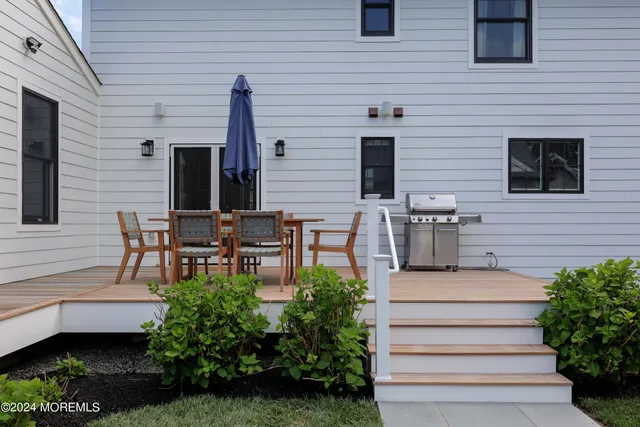 a patio with table and chairs and potted plants