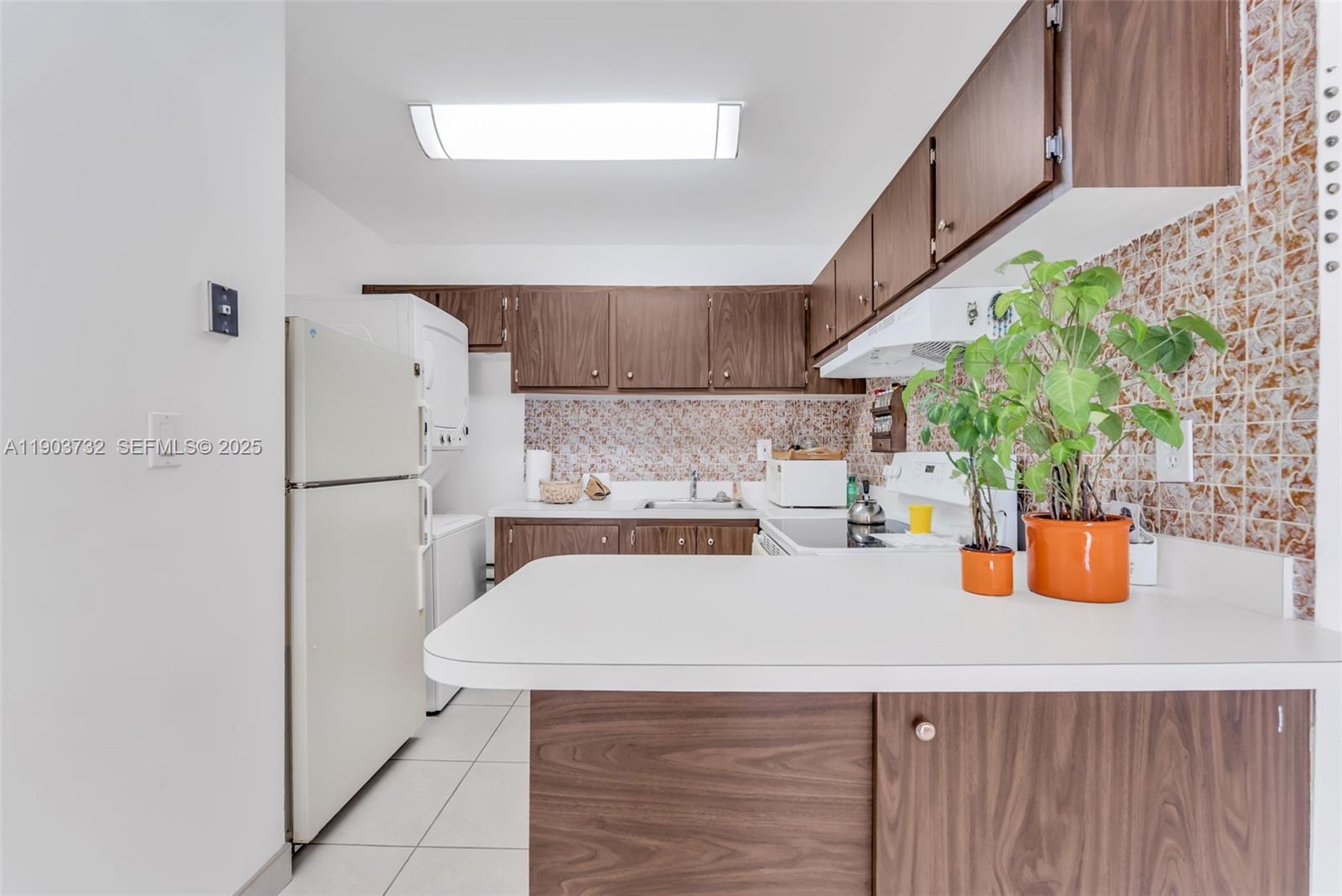 3661 Southwest 9th Terrace, Unit 402 Miami, FL 33135 - Photo 4 of 15 a kitchen with a sink a refrigerator and potted plant
