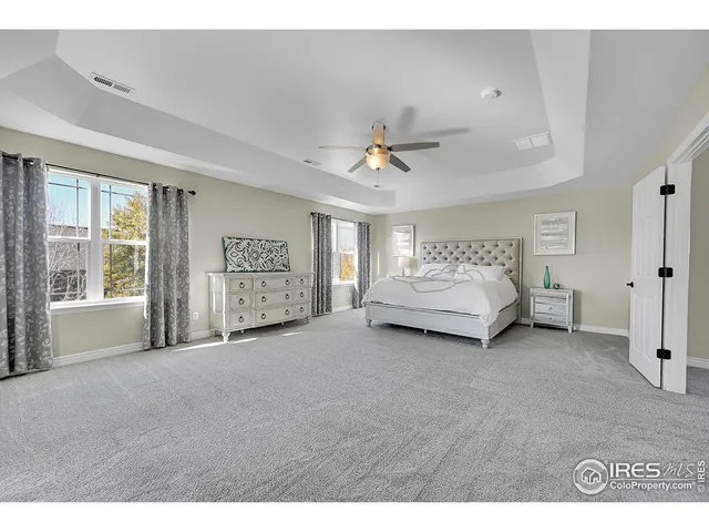 a spacious bedroom with a bed and a ceiling fan
