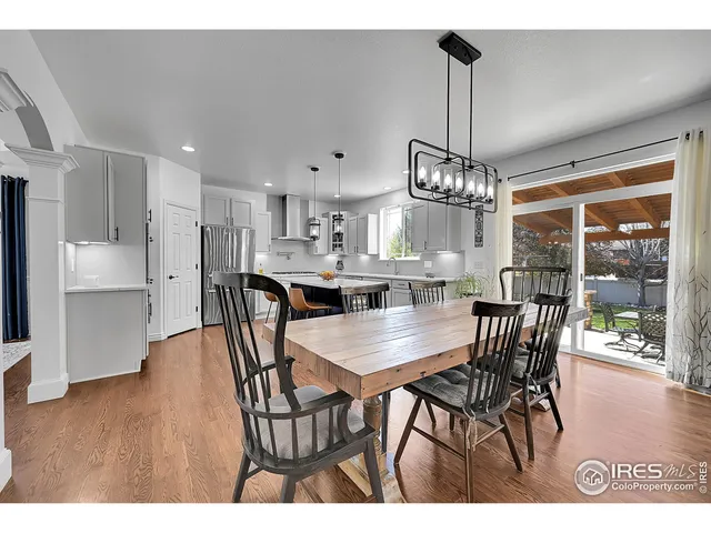 a view of a dining room and livingroom with furniture wooden floor a chandelier