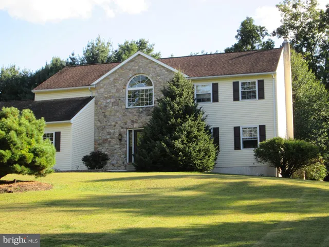 a front view of house with yard and green space