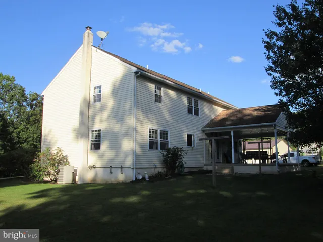 a view of a chairs and backyard with a small deck