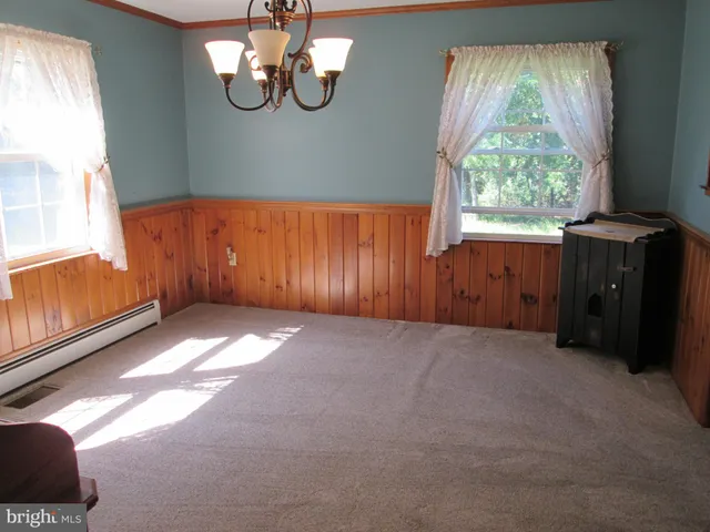 a view of a a dining room with furniture window and wooden floor