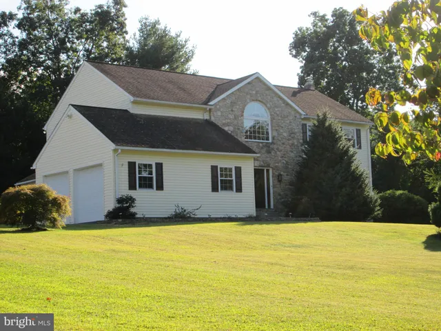 a view of a yard with plants and trees