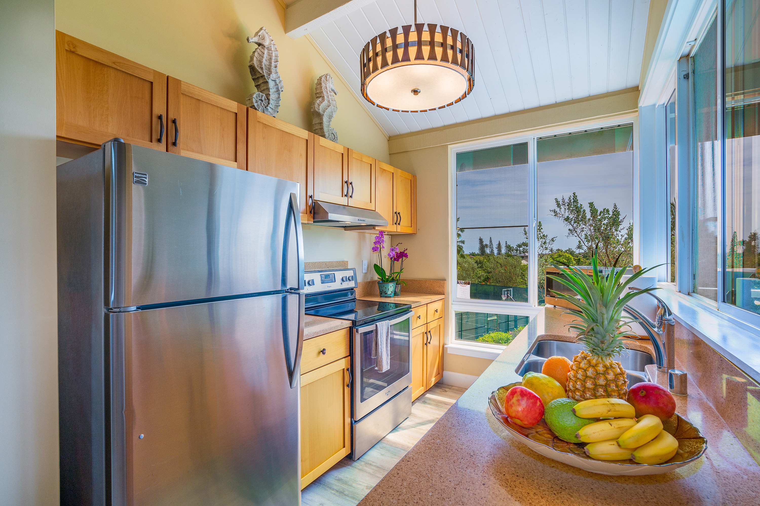 3811 Edward Road, Unit 2309 Princeville, HI 96722 - Photo 11 of 27 a kitchen with stainless steel appliances granite countertop a chimney a refrigerator and a stove
