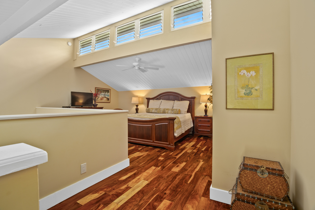 3811 Edward Road, Unit 2309 Princeville, HI 96722 - Photo 6 of 27 a living room with a bed furniture and a wooden floor