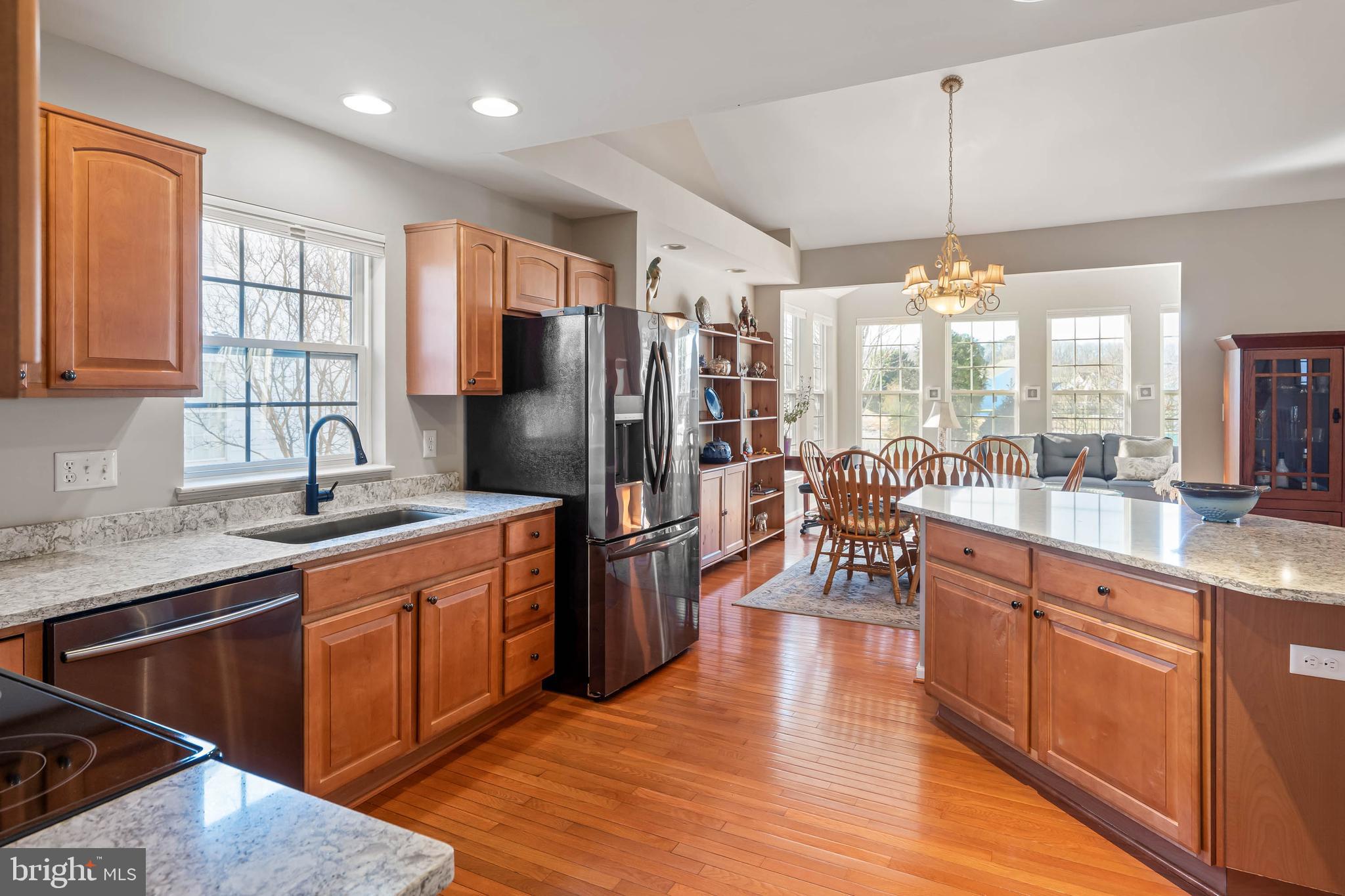 37140 Lord Baltimore Lane Ocean View, DE 19970 - Photo 12 of 56 a kitchen with stainless steel appliances granite countertop a refrigerator a sink dishwasher a stove and white countertops with wooden floor
