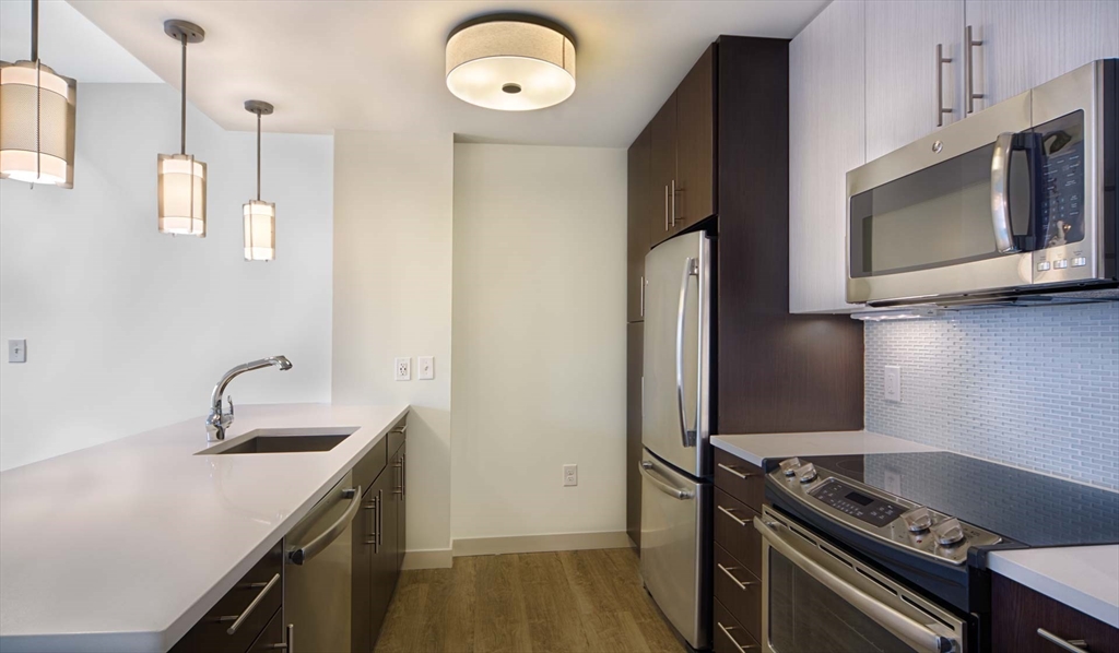 1 Canal Street, Unit 915 Boston, MA 02114 - Photo 1 of 11 a kitchen with a sink and a stove top oven