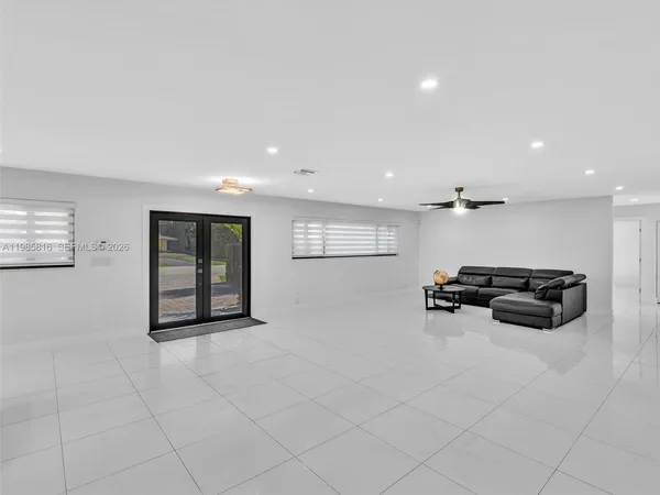 a living room with furniture and a flat screen tv with kitchen view