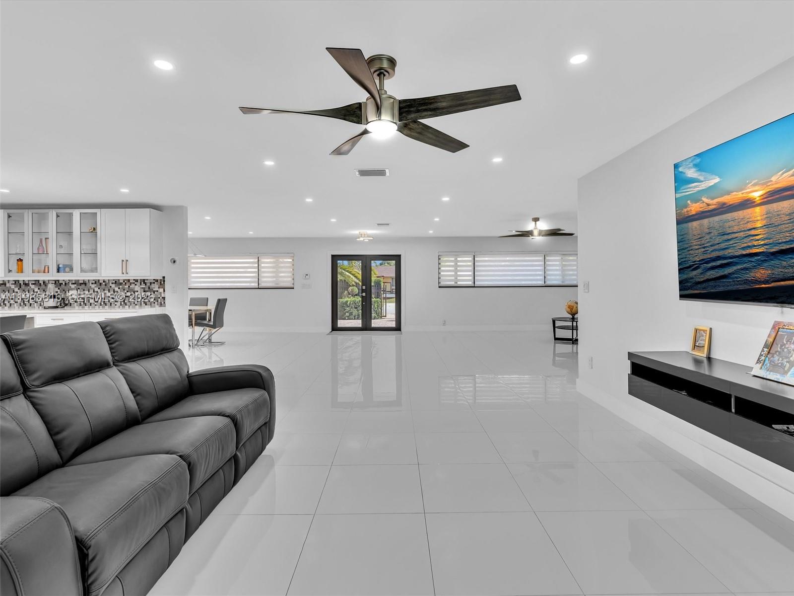 4501 Southwest 133rd Avenue Southwest Ranches, FL 33330 - Photo 41 of 100 a living room with furniture and a flat screen tv with kitchen view