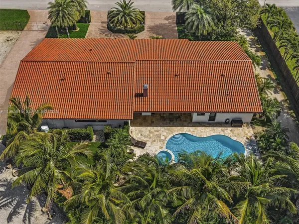 a palm tree sitting in front of a house with a yard