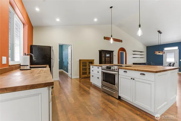 a kitchen with stainless steel appliances granite countertop a stove a sink and a refrigerator