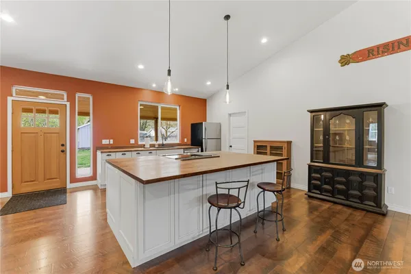 a kitchen with stainless steel appliances granite countertop a sink a stove and a wooden floors