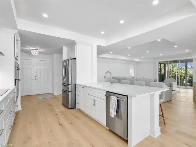 a kitchen with granite countertop white cabinets and stainless steel appliances