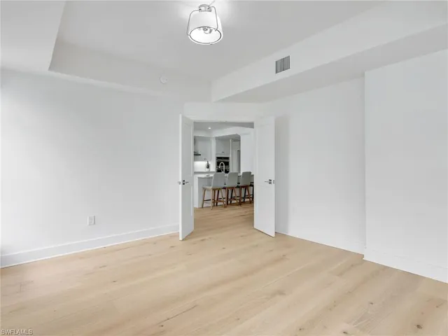 a spacious bedroom with a bed and glass door