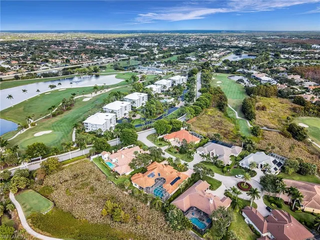 an aerial view of residential houses with outdoor space and trees