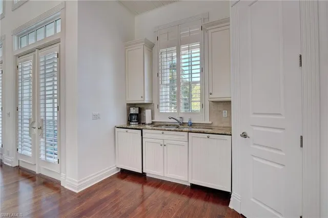 a living room with furniture kitchen view and a chandelier