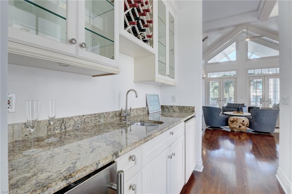 1551 Gulf Shore Boulevard South Naples, FL 34102 - Photo 22 of 44 a kitchen with sink cabinets and wooden floor
