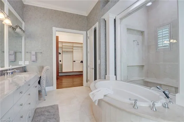 a spacious bathroom with a granite countertop sink a mirror and a bathtub
