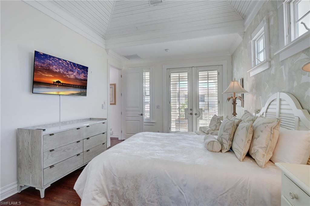 1551 Gulf Shore Boulevard South Naples, FL 34102 - Photo 38 of 44 a spacious bedroom with a bed and a flat screen tv