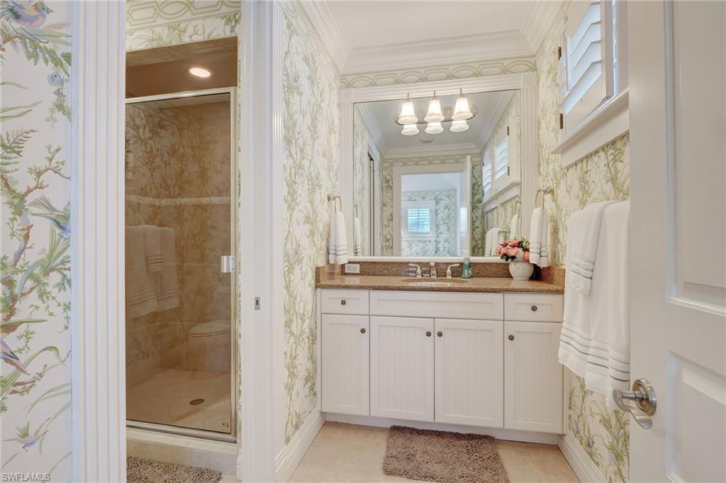 1551 Gulf Shore Boulevard South Naples, FL 34102 - Photo 42 of 44 a bathroom with a granite countertop sink a mirror and a shower