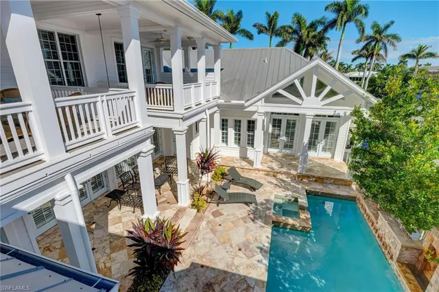 a view of a house with pool and chairs
