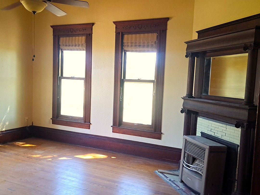 105 Davis Drive Thorndale, TX 76577 - Photo 17 of 21 Rich wood trim frames the windows and a classic fireplace mantel anchors the space.
