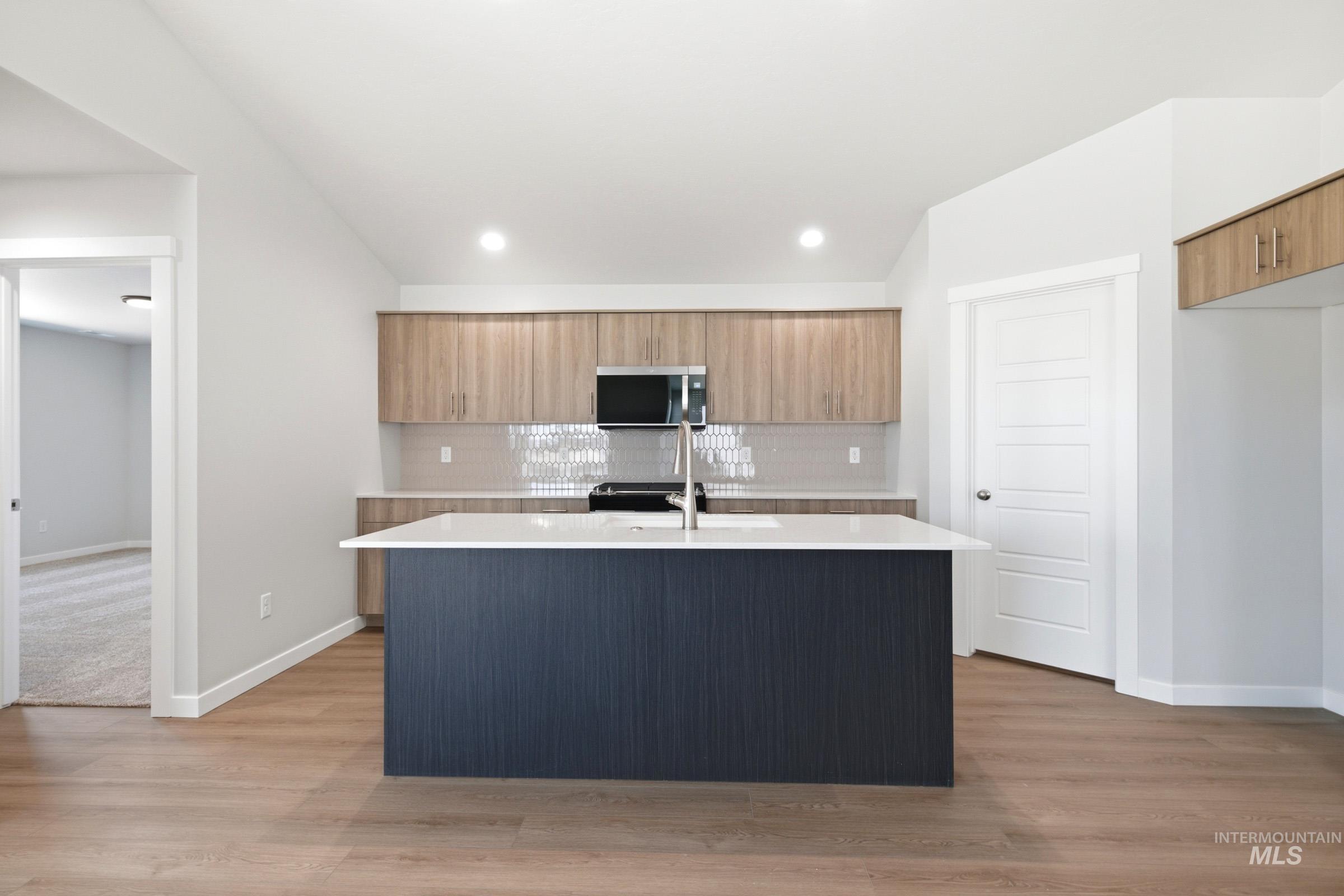 1184 West Jasper Street Meridian, ID 83642 - Photo 3 of 18 Contemporary kitchen featuring a dark blue island with a white countertop and an integrated sink with a gooseneck faucet