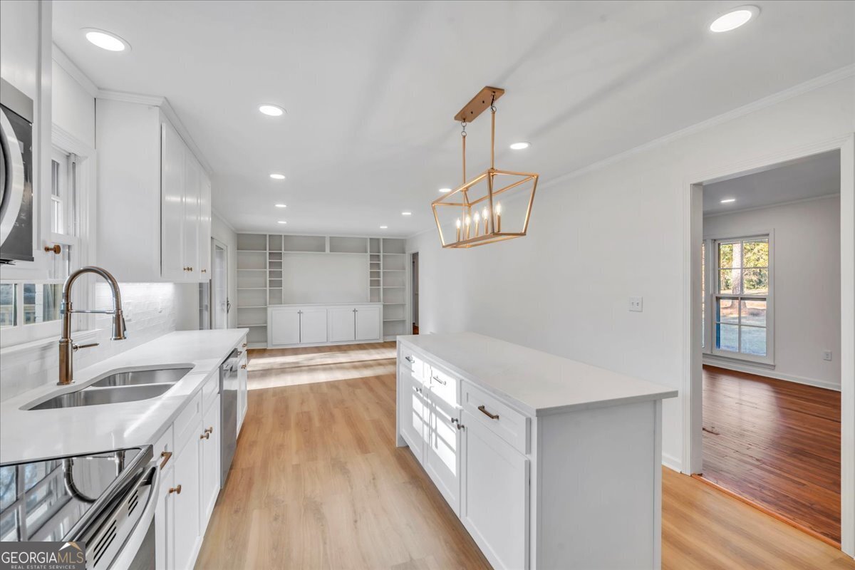 1806 Knox Street Dublin, GA 31021 - Photo 14 of 49 a view of a kitchen with kitchen island a sink wooden floor and living room