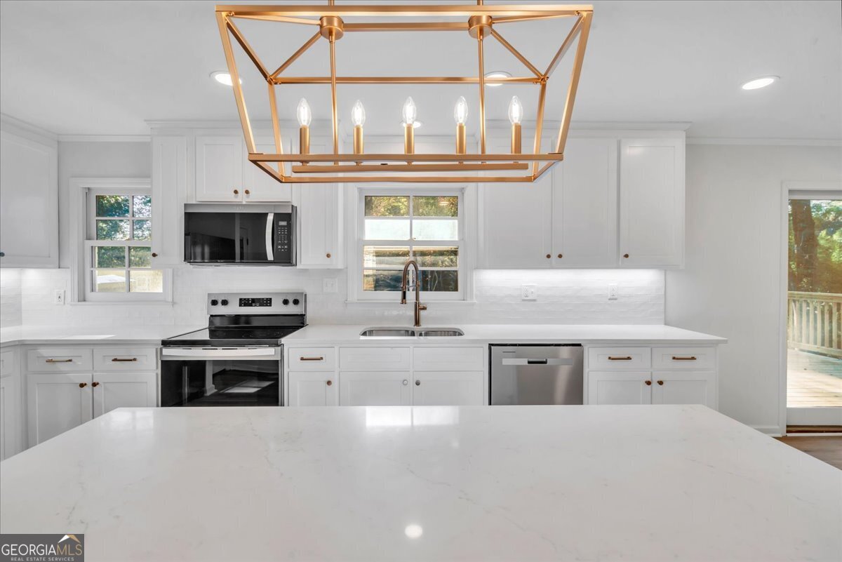 1806 Knox Street Dublin, GA 31021 - Photo 15 of 49 a kitchen with cabinets a window and stainless steel appliances