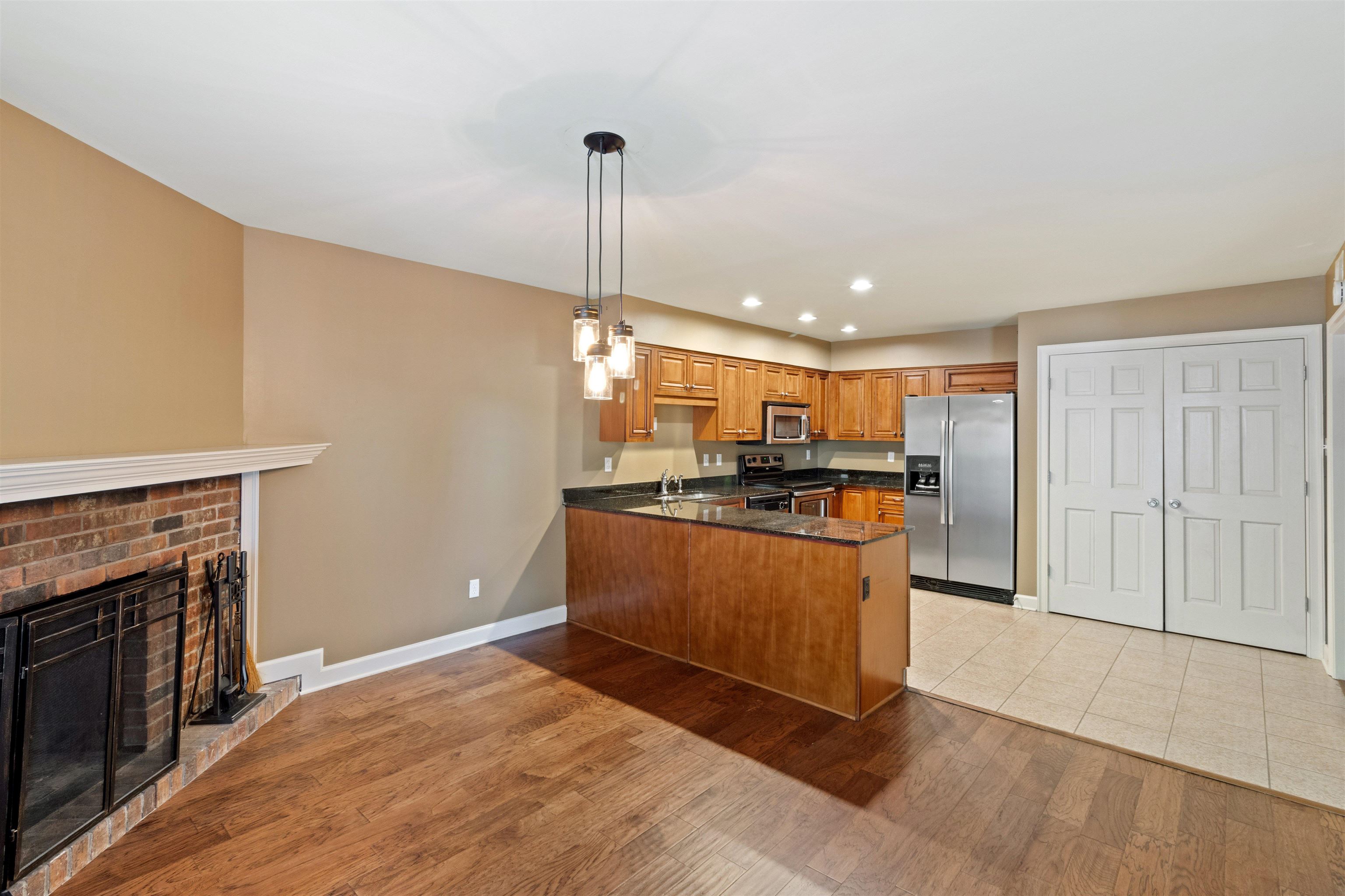 700 St Augustine Square, Unit D Memphis, TN 38104 - Photo 11 of 31 a kitchen with stainless steel appliances granite countertop a refrigerator a oven a sink and a wooden floors