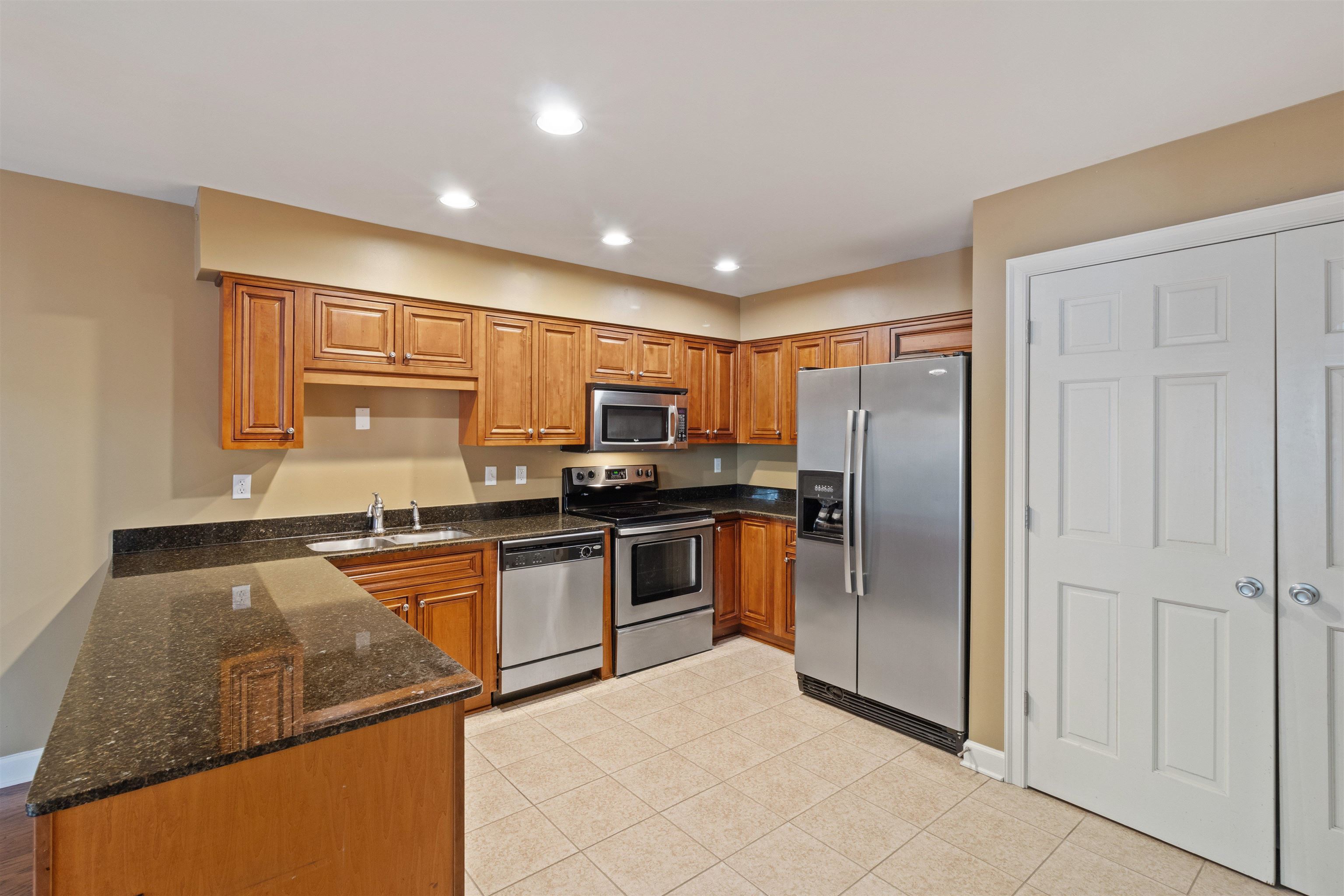 700 St Augustine Square, Unit D Memphis, TN 38104 - Photo 14 of 31 a kitchen with stainless steel appliances granite countertop a refrigerator sink and stove